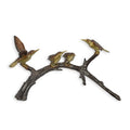 A BRONZE SCULPTURE OF FOUR HUMMINGBIRDS ON A BRANCH