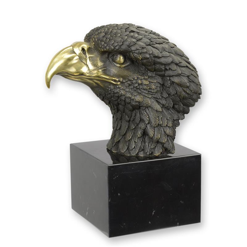 Bronzen sculptuur van een adelaarskop met goudkleurige snavel op zwarte marmeren sokkel.