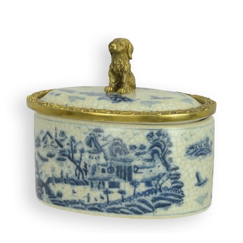 Ovale blauw-witte porseleinen doos met vergulde bronzen rand en hondje als dekselknop